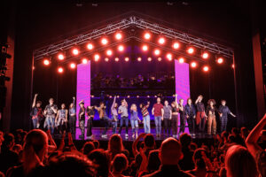Full cast of Jagged Little Pill Musical on stage in front of a crowd