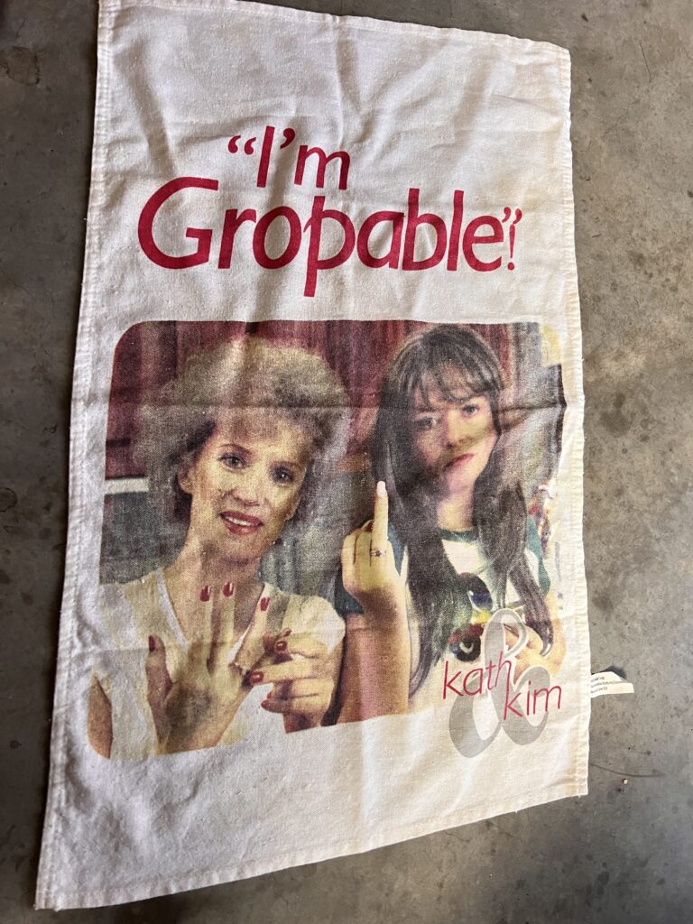 Kath and Kim tea towel with the phrase "I'm Gropable!"